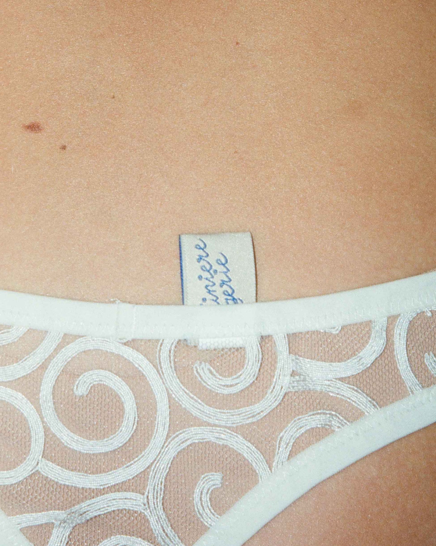 An ivory-colored, floral patterned brief