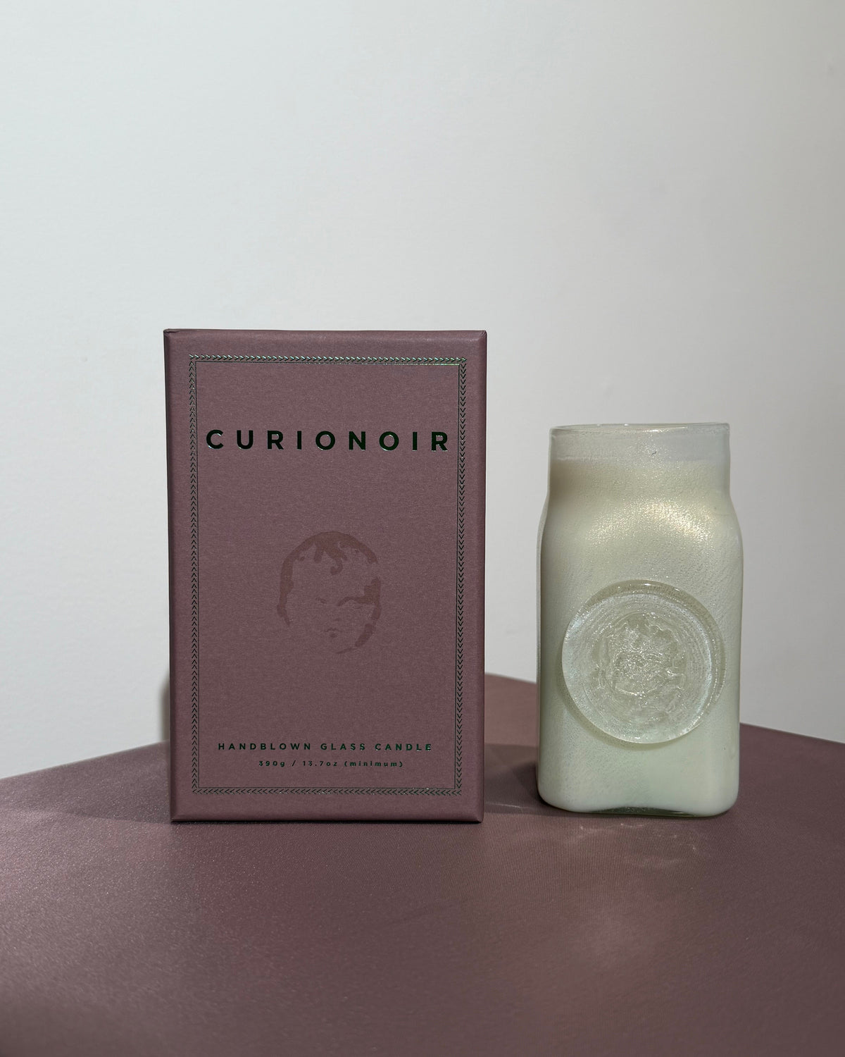 kihikihi candle beside curionoir box with on purple fabric