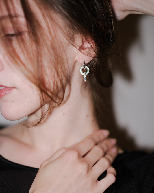 close up shot of loop loop hoop worn by woman looking away from frame. 