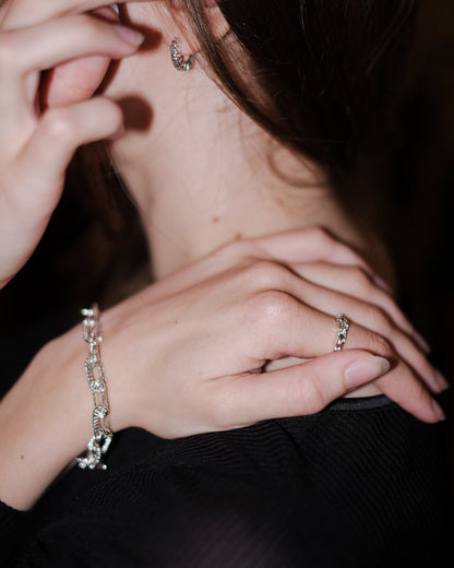 Side view of Alexandra Dodds Teeth Chain Link Bracelet on model’s wrist, resting on shoulder.