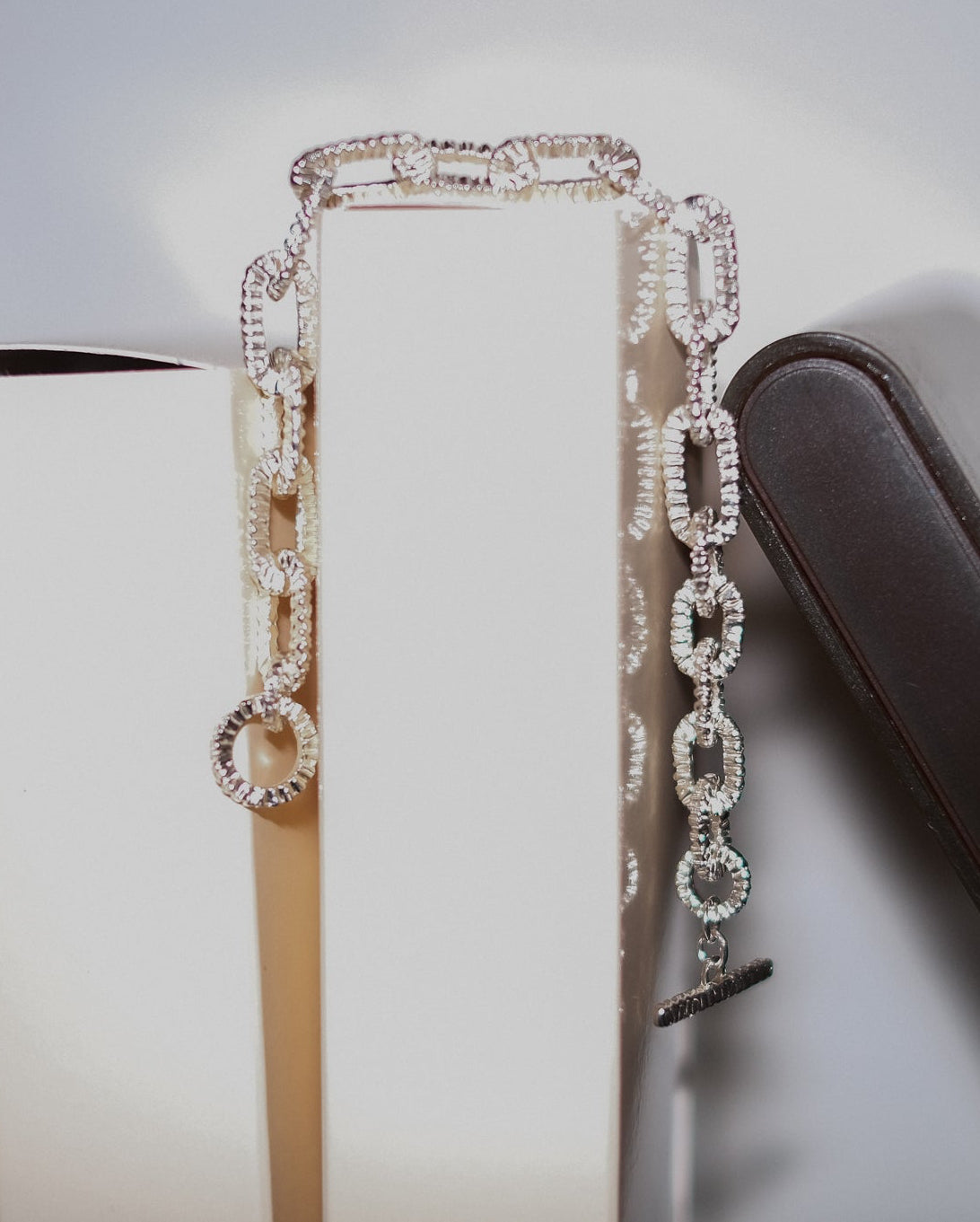 Front view of Alexandra Dodds Teeth Chain Link Bracelet draped over a surface.