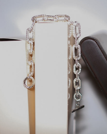 Front view of Alexandra Dodds Teeth Chain Link Bracelet draped over a surface.