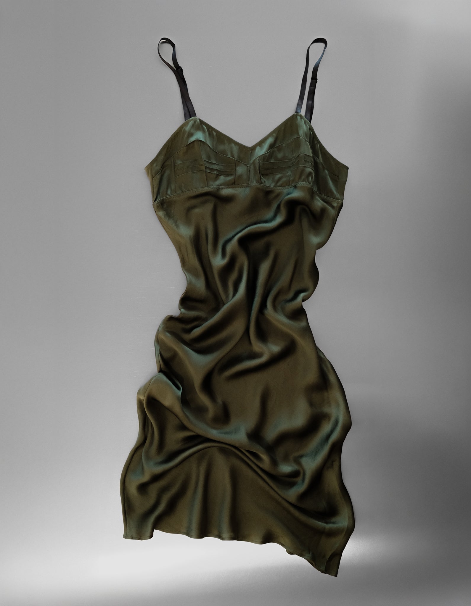 Green satin slip dress on a gray background