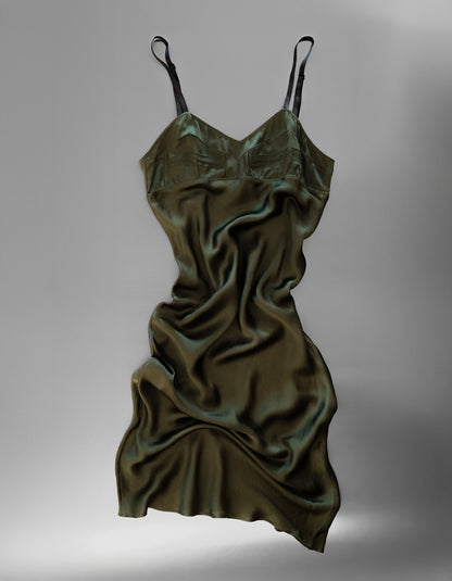Green satin slip dress on a gray background