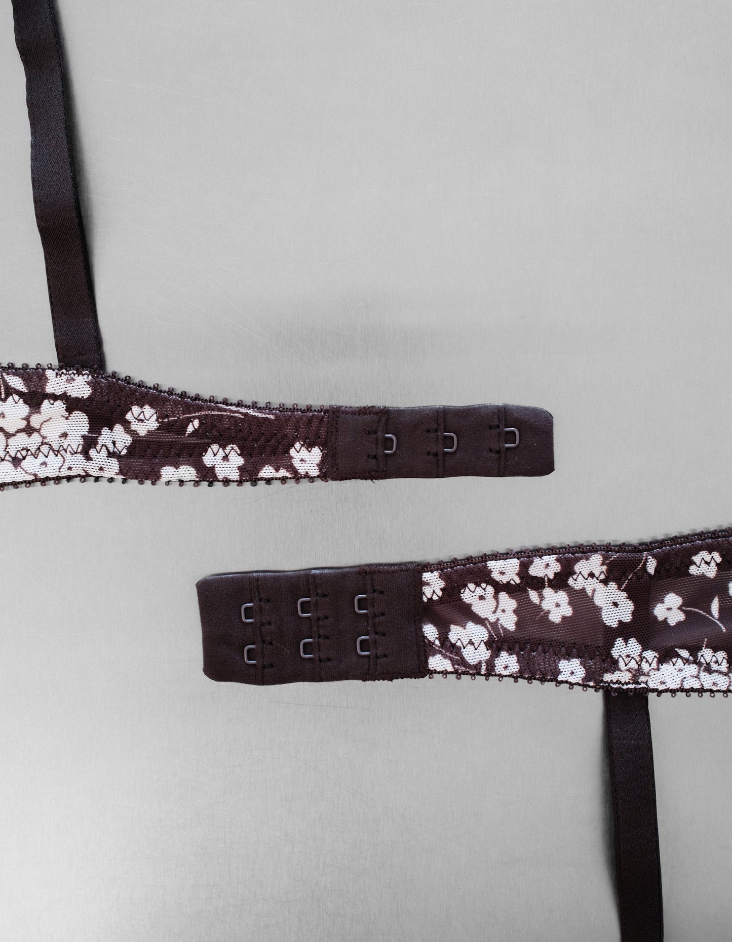 Floral lace bra strap on a light gray background