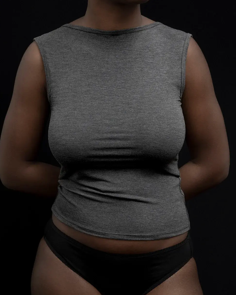 A woman wearing a fitted sleeveless heather gray top and black underwear, shown from the neck down against a black background.