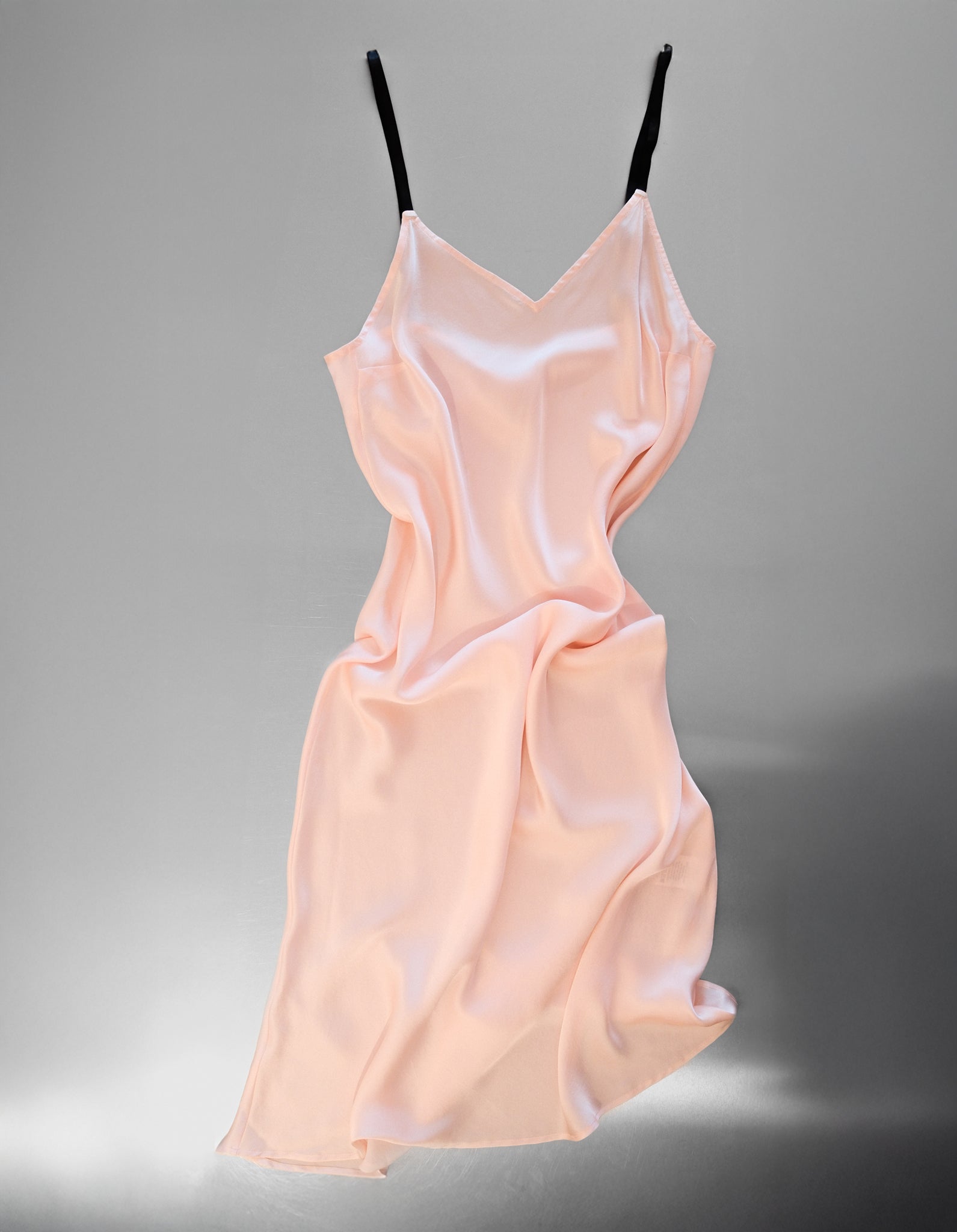 Light pink slip dress on a gray background
