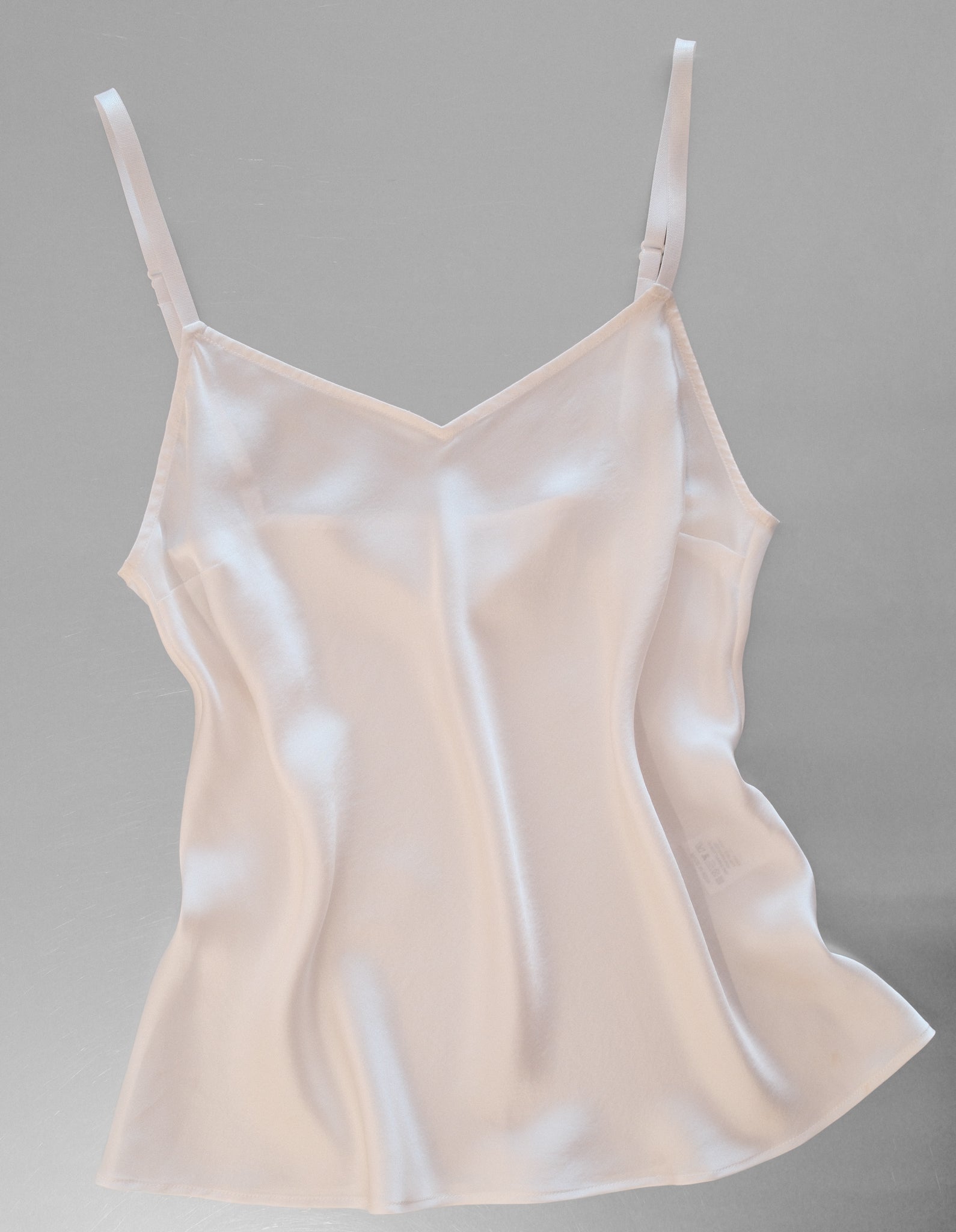 Beige satin camisole on a gray background