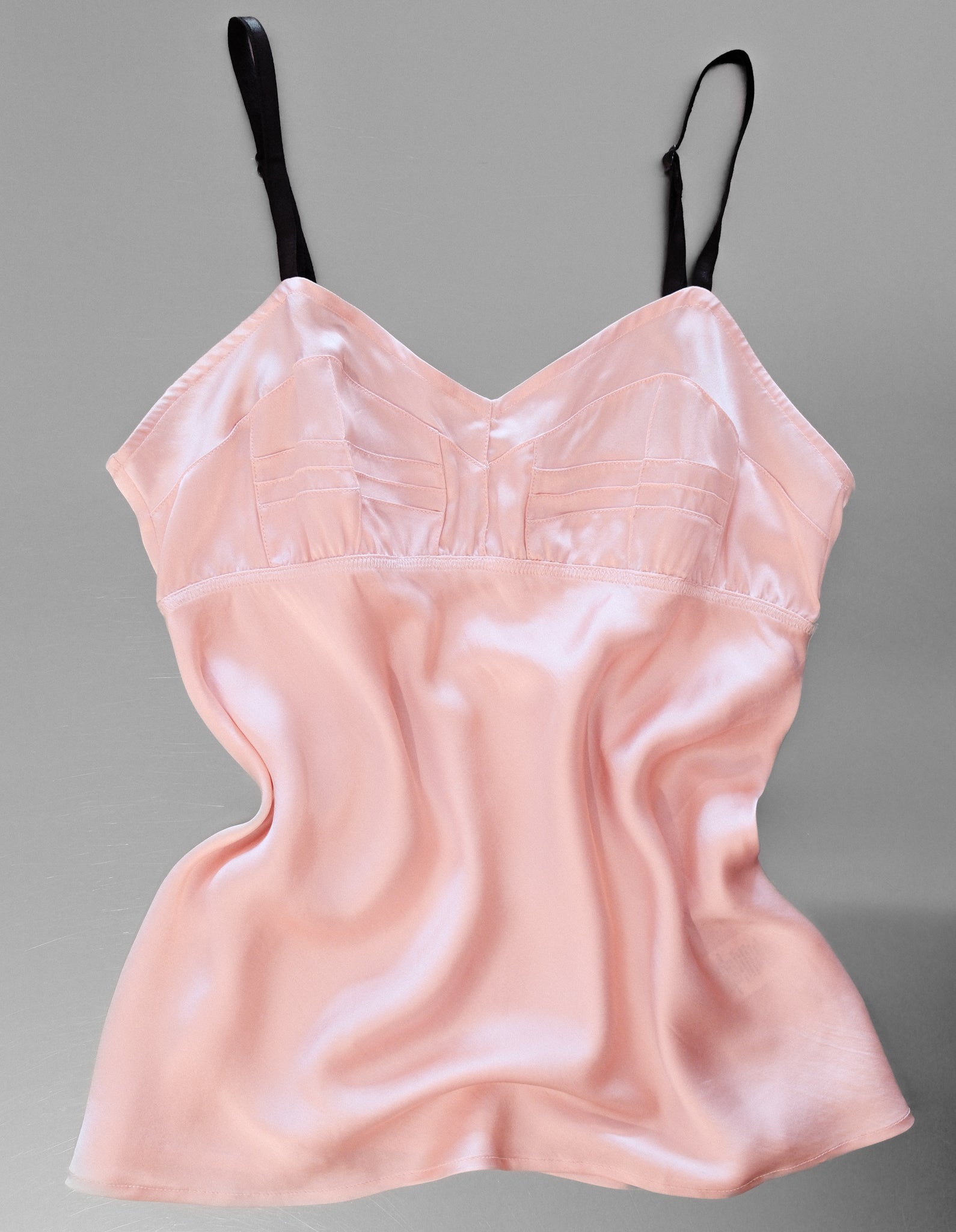 Pink satin camisole on a gray background